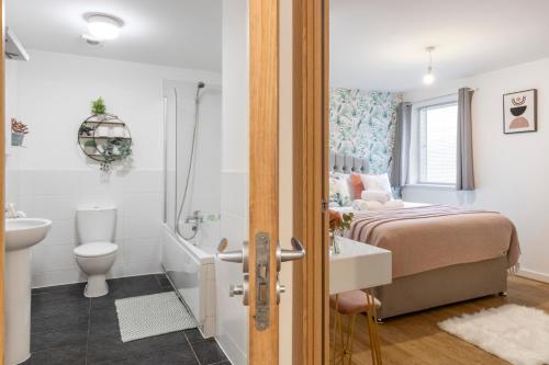 a bedroom with a bed and a sink and a toilet at Tranquil Urban Haven in London