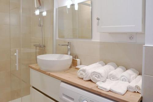 La salle de bains est pourvue d'un lavabo et d'un comptoir avec des serviettes. dans l'établissement Le Majorelle-centre ville-accès 24h- parking free, à Montluçon