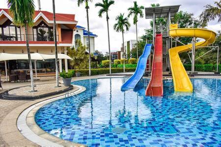 a swimming pool with a slide in a resort at Long Stay Villa in Swiss Town! in Devanahalli-Bangalore