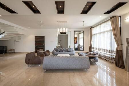 a large living room with a couch and chairs at Long Stay Villa in Swiss Town! in Devanahalli-Bangalore