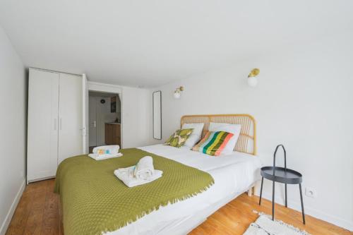 a bedroom with a large bed with a green blanket at 317 Suite Martin - Superb apartment in Paris in Paris