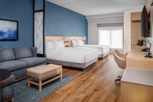 Habitación de hotel con cama y sofá en Hyatt Place St Augustine Vilano Beach, en St. Augustine