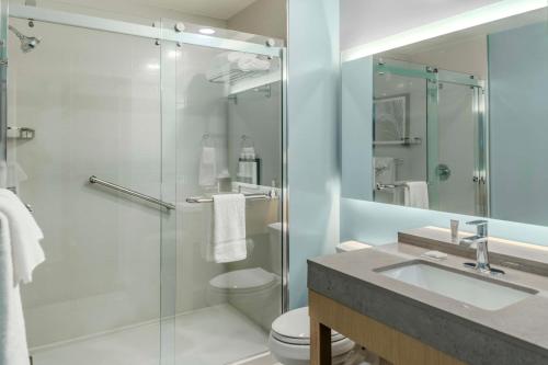 a bathroom with a shower and a toilet and a sink at Hyatt Place St Augustine Vilano Beach in St. Augustine