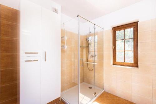 a shower with a glass door in a bathroom at Rezydencja Nadmorska Rogowo in Rogowo