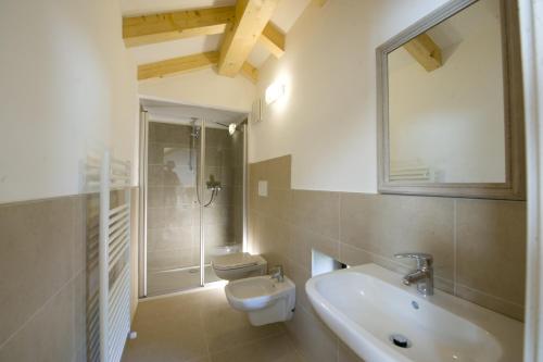 a bathroom with a sink and a toilet and a mirror at La Villa degli Orti in Borgo