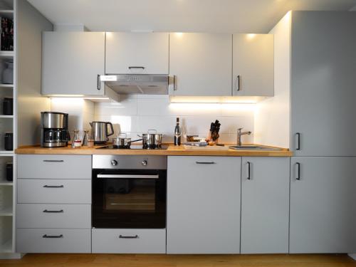 a kitchen with white cabinets and a stove at Swebenhus boven - FeWo mit großer Dachterrasse in Plau am See