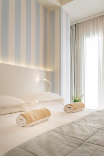 a bedroom with two beds and a window at Hotel Villa Rosa Riviera in Rimini