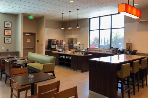un restaurante con mesas y sillas y una cafetería en Country Inn & Suites by Radisson, San Jose International Airport, CA, en San José
