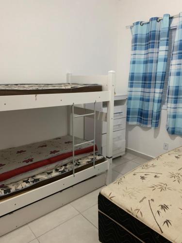 a bedroom with two bunk beds and a bed at Apto em Ubatuba divisa com a Praia de Itagua e facil acesso as praias fica ao lado do Atacado Tenda na rodovia Rio Santos in Ubatuba