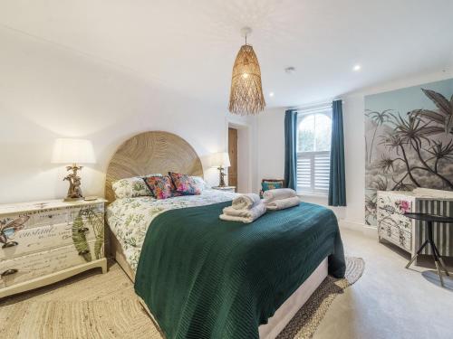 a bedroom with a large bed with towels on it at Clematis House in Saint Columb Major
