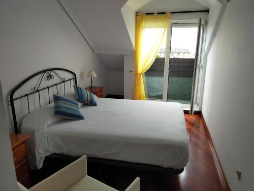 a bedroom with a bed and a large window at CASA MANUELA in Suances