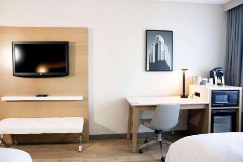 um quarto de hotel com uma secretária e uma televisão na parede em Radisson Hotel Casa Grande em Casa Grande
