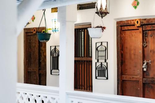 a staircase with wooden doors and potted plants at Emerald Palm Courtyard Hotel in Zanzibar City
