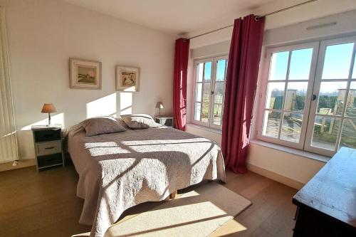a bedroom with a bed and windows with red curtains at Belle demeure avec piscine à Bourgueuil 5 ch/10 p in Bourgueil