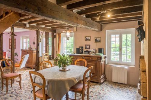 een keuken en eetkamer met een tafel en stoelen bij Chantilly ,petit déjeuner et table d'hôtes possible in Noyers