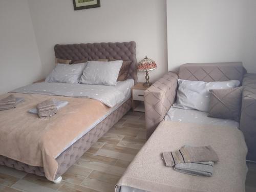 a bedroom with two beds and a couch at MAL Apartman in Soko Banja