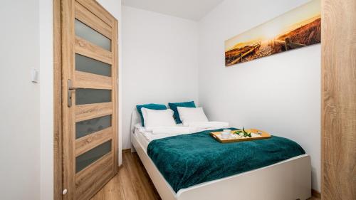 Apartamenty Sun & Snow City Link في وارسو: غرفة نوم صغيرة بسرير مع باب خشبي