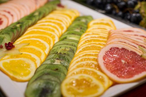 a plate of food with cucumbers oranges and other foods at MariSol in Świnoujście