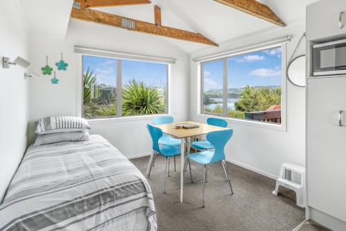 a bedroom with a bed and a table and chairs at The Shed - Raglan Holiday Home in Raglan