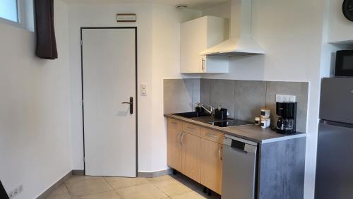 a kitchen with a sink and a refrigerator at studio Les merles à Saint-Égrève in Saint-Égrève