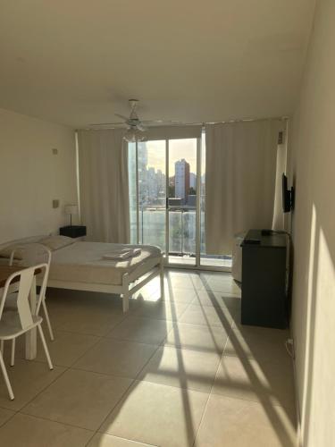 1 dormitorio con cama y ventana grande en Monoambiente zona centro en Rosario