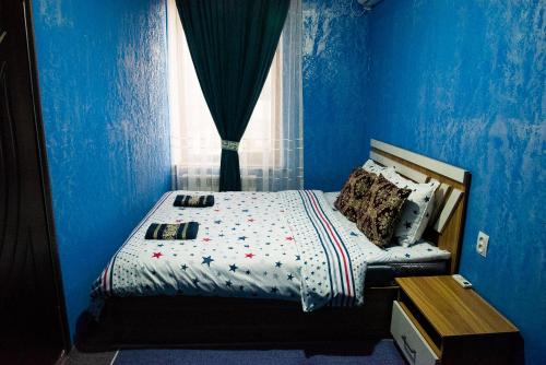 a blue bedroom with a bed with a window at Rajab Bobo guest house in Samarkand