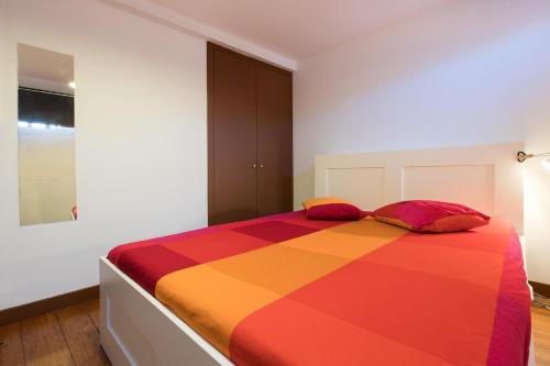 a colorful bed with two pillows in a bedroom at TAIPAS GUEST HOUSE in Porto