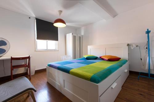 a bedroom with a large bed with colorful sheets at Taipas Guest House in Porto