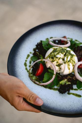 a person holding a plate of food with a salad at Lures Hotel in Kalkan