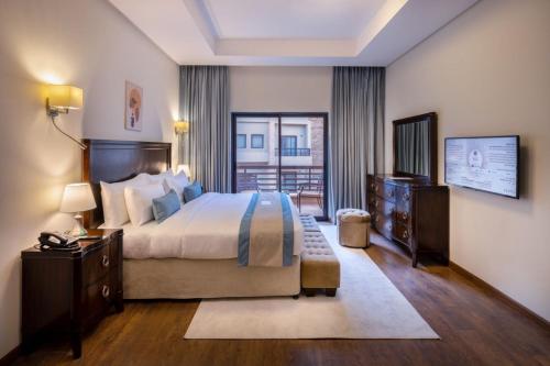 a bedroom with a large bed and a balcony at Obeir Resident Hotel - فندق اوبير السكني in Riyadh
