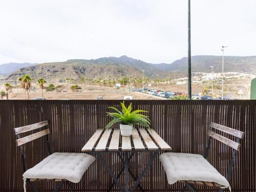 einen Tisch mit 2 Stühlen und einen Tisch mit einer Pflanze auf dem Balkon in der Unterkunft Live Caletillas Mencey in Candelaria