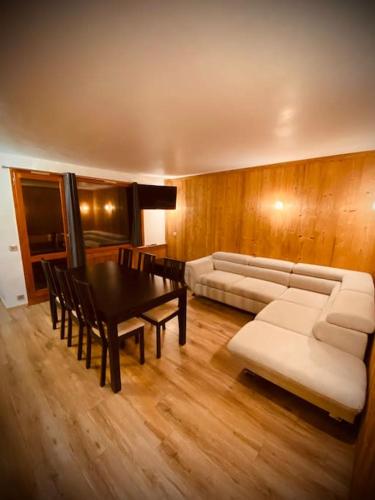 un salon avec un canapé, une table et des chaises dans l'établissement Joli appt 6 pers 2ch Belle Plagne pied des pistes, à La Plagne Tarentaise
