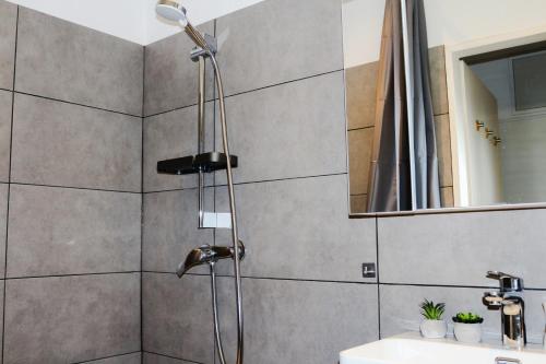 La salle de bains est pourvue d'un pommeau de douche et d'un lavabo. dans l'établissement Timeless Apartment Bremen-Neustadt, à Brême