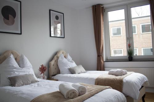 - une chambre avec 2 lits et des serviettes dans l'établissement Timeless Apartment Bremen-Neustadt, à Brême