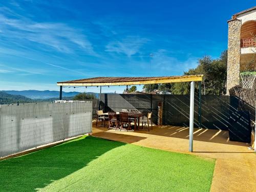 a patio with a gazebo and a table and chairs at Casa MAJU in Pals