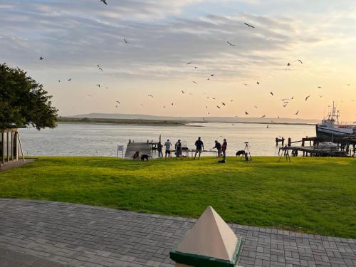 a group of people flying kites over a body of water at Laaiplek Hotel in Velddrif