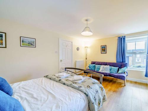 een slaapkamer met een bed en een bank bij 3 Bed in Cockermouth 59384 in Cockermouth