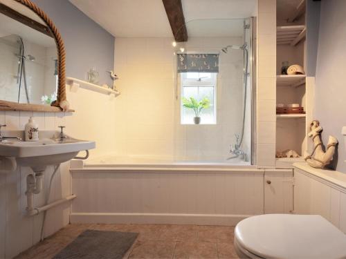 a bathroom with a tub and a toilet and a sink at 3 bed in Braunton 85884 in Barnstaple