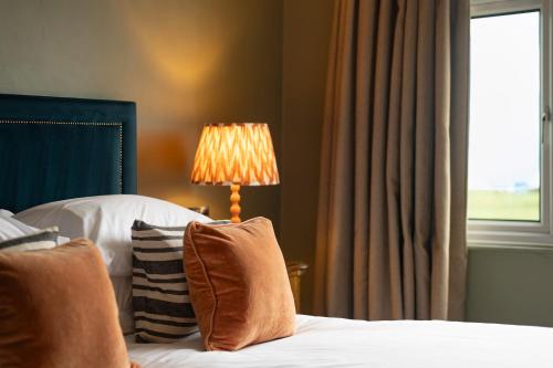 a bedroom with a bed with a lamp and a window at East Beach Guest House in Littlehampton