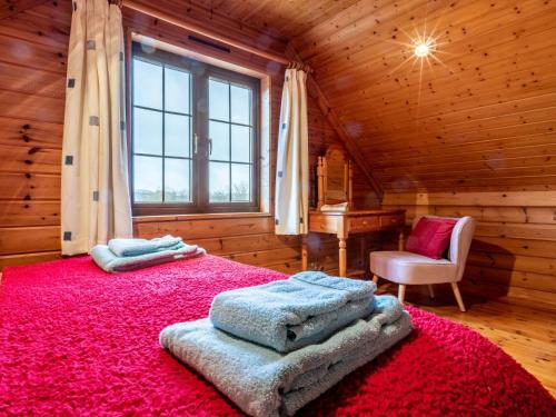 a bedroom with a large red bed in a wooden house at 3 Bed in Clovelly 00368 in Clovelly