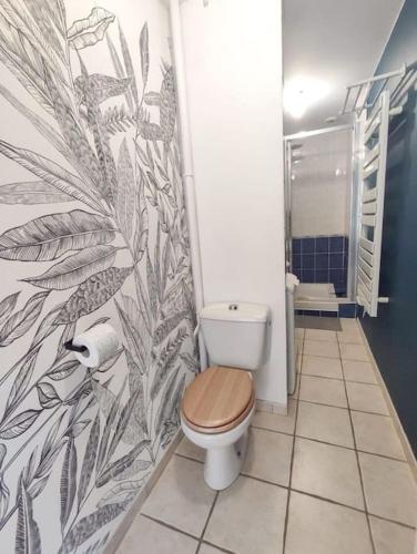 La salle de bains est pourvue de toilettes et d'une fresque murale. dans l'établissement Terre de Bretagne, appartement entre port et plage, à Audierne