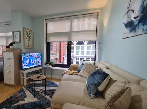 - un salon avec un canapé blanc et une grande fenêtre dans l'établissement Impressive Apartment at Leeds City Centre, à Leeds