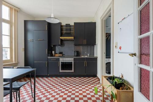 a kitchen with black cabinets and a checkered floor at The Workspace w/Free Parking in Antwerp