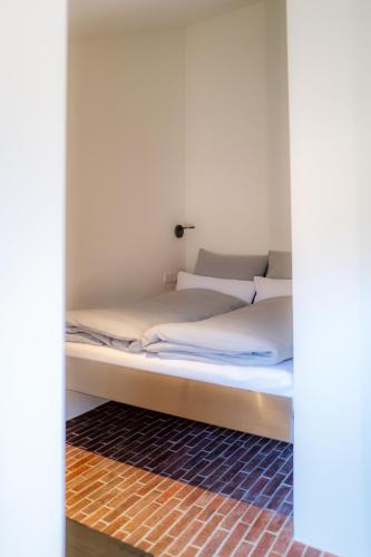 a bed with white sheets and pillows in a room at AMTENBRINKSHOF Appartements in Gütersloh