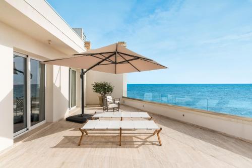 a patio with a table and an umbrella at Mare Dentro in Calabernardo
