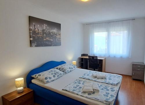 a bedroom with a blue bed and a desk at Turnic in Rijeka