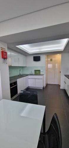 a kitchen with white cabinets and a white counter top at Casa Filó in Peso da Régua