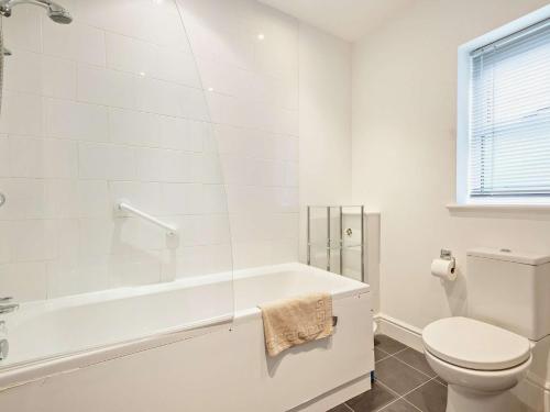 a white bathroom with a tub and a toilet at 2 Bed in Cheltenham 49336 in Southam
