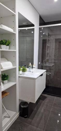 a bathroom with a white sink and a shower at Casa Filó in Peso da Régua