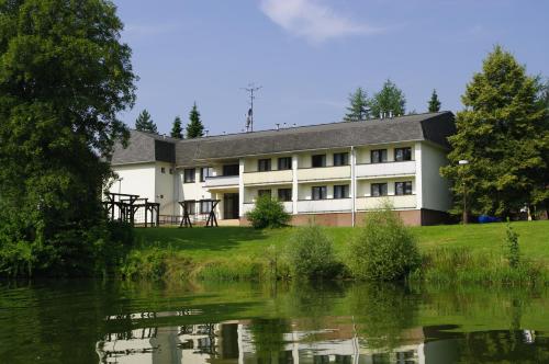 a building next to a body of water at Hotel Jaškovská Krčma in Horní Těrlicko